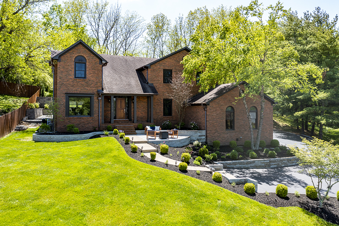 Brick Home with large front lawn typical of real estate in The Woods, Kentucky